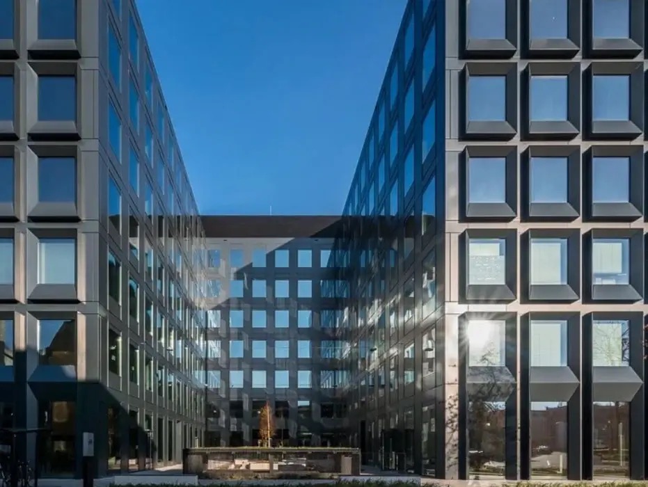 Modern gebouw met grote aluminium glasgevels rond een binnenplaats