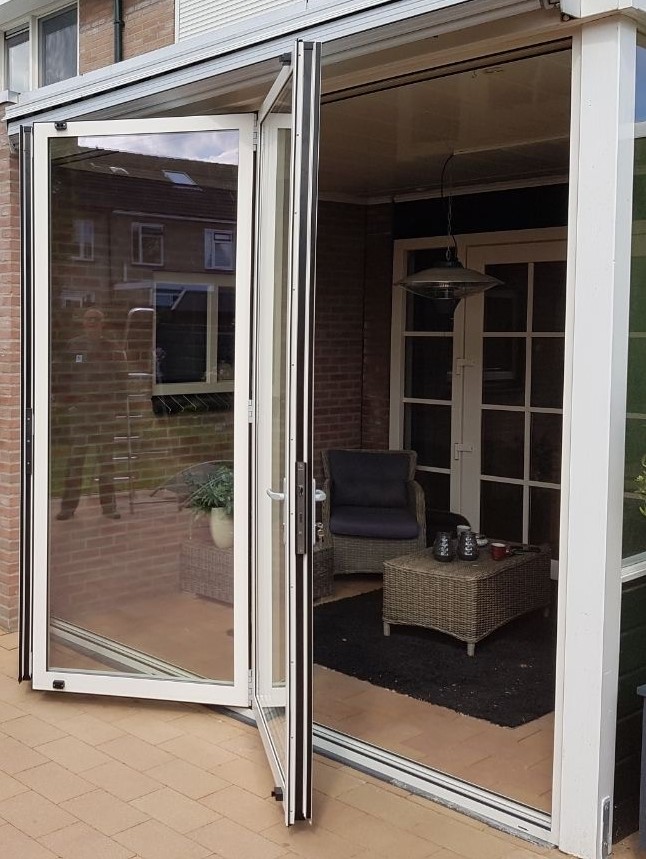 Crème aluminium schuifwand bij een serre, geopend
