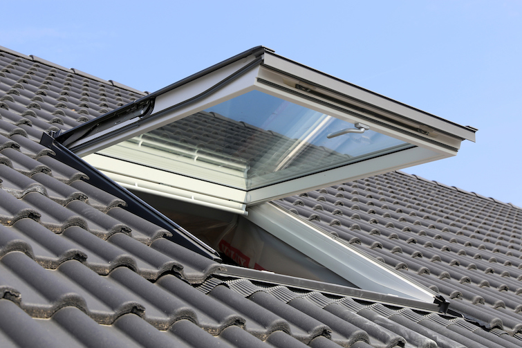 Geopend Velux tuimeldakraam op een grijs pannendak